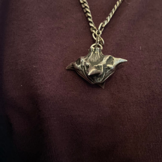 a person wearing a necklace with a bird on it